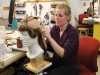 A hair wig stylist focuses on the job ahead.