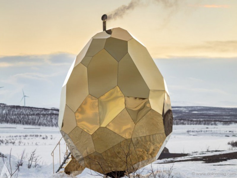 A’Design Award — The Solar Egg: Winner of an A’Design Award, the Solar Egg is a public sauna in Kiruna, Sweden, that is constructed with stainless golden mirror sheeting. The egg’s interior is made of wood, with the wall panels and floor decking made out of pine. The bench is made of aspen. In the centre of the egg stands the wood-heated, heart-shaped sauna stove made of iron and stone | Photo courtesy of A’Design Award