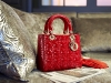 A red Lady Dior handbag with matching gloves