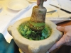 A rustic mortar and pestle meet to produce a tasty pesto.