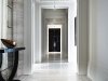 Reflecting the pristine and stately feel of an art gallery, this seemingly endless hallway features slab marble floors and a stone mirror frame that holds an antique-cut mirror wall