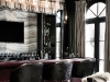 This luxurious great-room bar boasts a slab onyx back wall with a leather-wrapped, plum-coloured bar and sculpted glass lighting