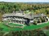 The main residence spans 21,630 square feet on two levels with a solid granite exterior, two elevators, an indoor pool, a main floor master suite, plus three additional bedroom suites