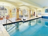 The light-filled pool complex has several large seating areas, expansive stone decks, a fireplace, a hot tub and three French door walkouts to the garden