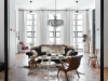 The soaring art deco windows are a magnificent feature of the living space. The brown velvet sofa and 1950s chairs were second-hand finds, and the skin was bought on eBay. The lacquered coffee table was designed by Laureen Rossouw and the two side tables from Tonic Design create a “stage” effect. They also introduce some brass into the otherwise neutral palette. The crystal chandelier from Delos adds to the sense of old-world glamour