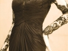 A dramatic black dress garners attention for its original lace neckline and sleeve style.