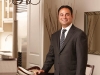 Sam Mizrahi makes himself the centrepiece in Lytton Park Townhomes’ model suite dining room.