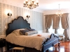 Much like Marie Antoinette’s bed chamber, these private quarters are adorned with planked flooring, flourishing drapery, and European light fixtures. An abundance of silk pillows complement the lush bedding, accentuated by a hand-carved headboard.
