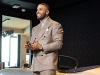 Jam standing on the “dezervator,” the elevator built by developer Gil Dezer specifically for the Porsche Tower. It can bring the cars directly up to the units in fewer than 60 seconds | Suit & Shoes: Suit Supply Turtleneck: H&M | Photography By Jesse Milns