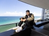 Jam reflecting on his ascending career from the 16th floor of the Porsche Tower in Miami | Jacket: Palm Angels Pants: 1017 ALYX Shirt: John Elliott (Available at Saks Fifth Avenue, Brickell City Center) Hat: The Hat Dealers from LA Shoes: Nike | Photography By Jesse Milns