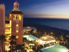 Night view of the pool and ocean at the Don Cesar Hotel.