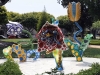 I Want to Fly to the Universe in the reflecting pool features a vivid yellow primordial face, while (right) Hymn of Life – Tulips depicts outsized fibreglass flowers among white lilies | Photo Courtesy Of Yayoi Kusama